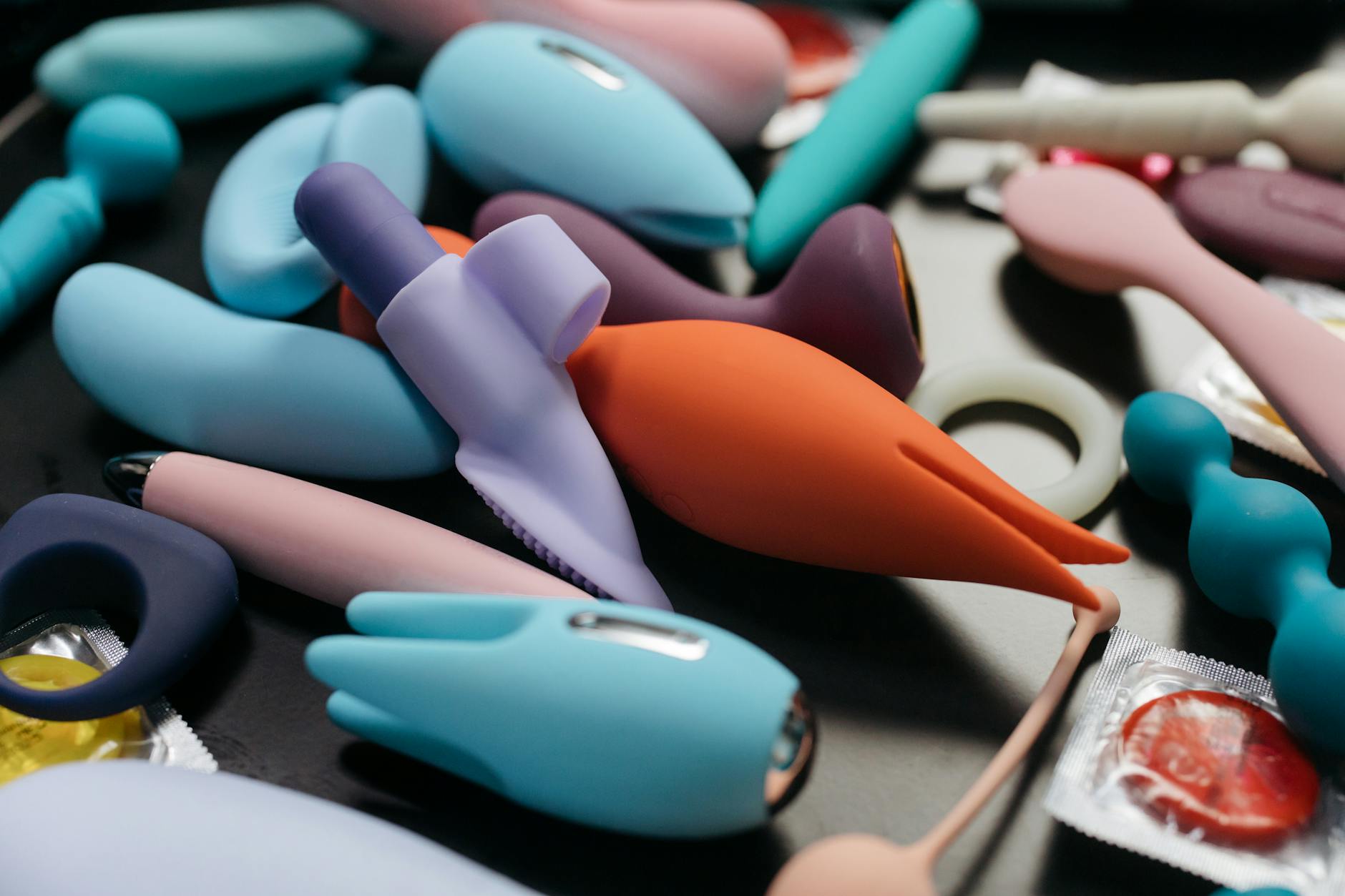 Colorful vibrators and wellness items in a basket with a fresh flower