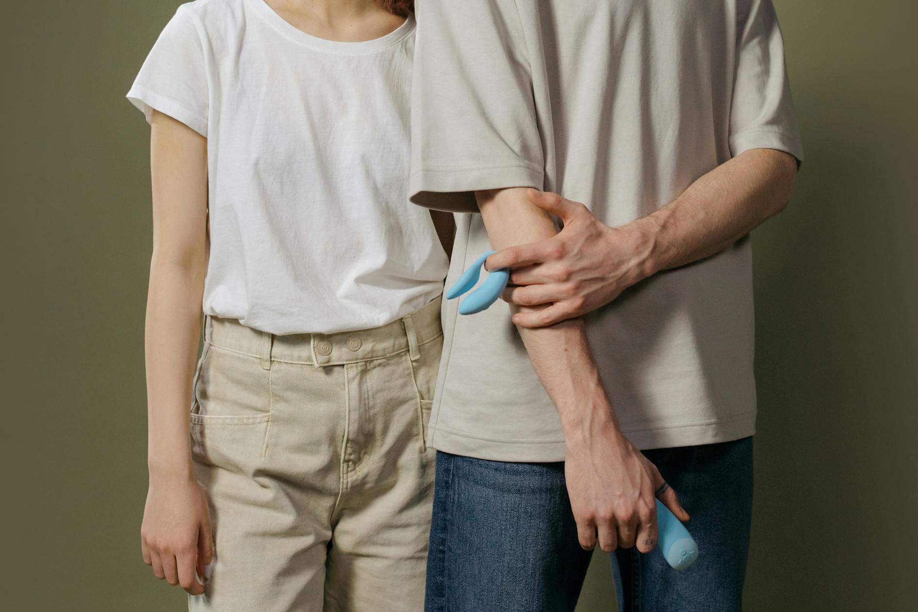 A couple holding a blue lemon clitoral vibrator together, exploring intimacy and pleasure recovery.