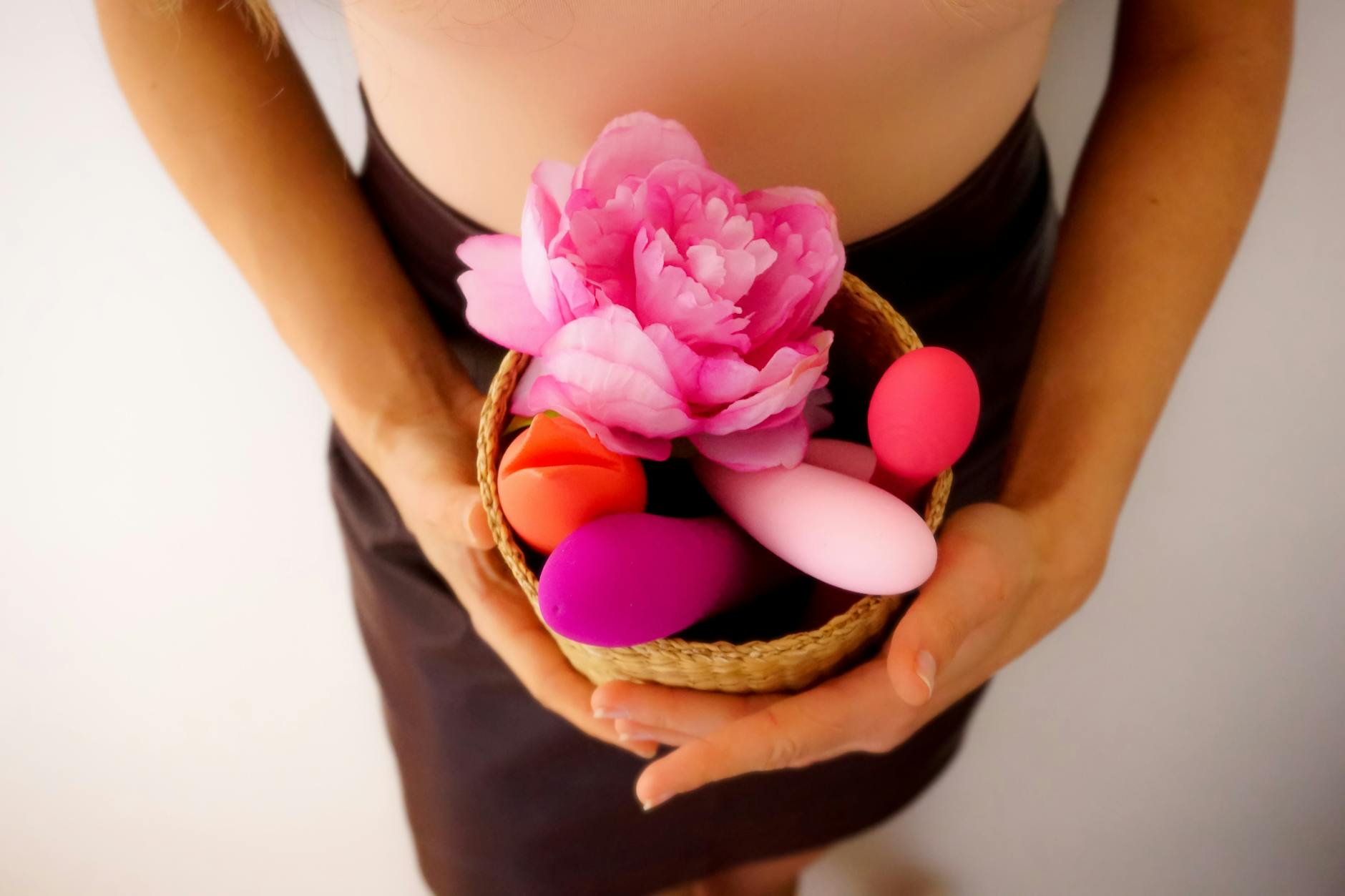 Woman holding a vibrator thoughtfully, symbolizing first-time consideration and comfort